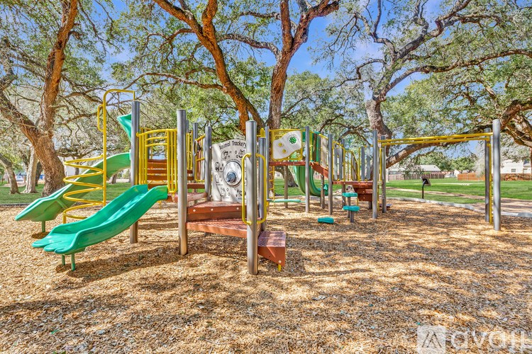 A playground with a green slide and a yellow and green play structure.