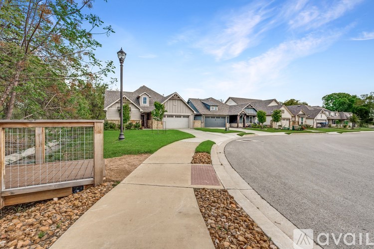 A residential street with houses on both sides and a sidewalk in the foreground.