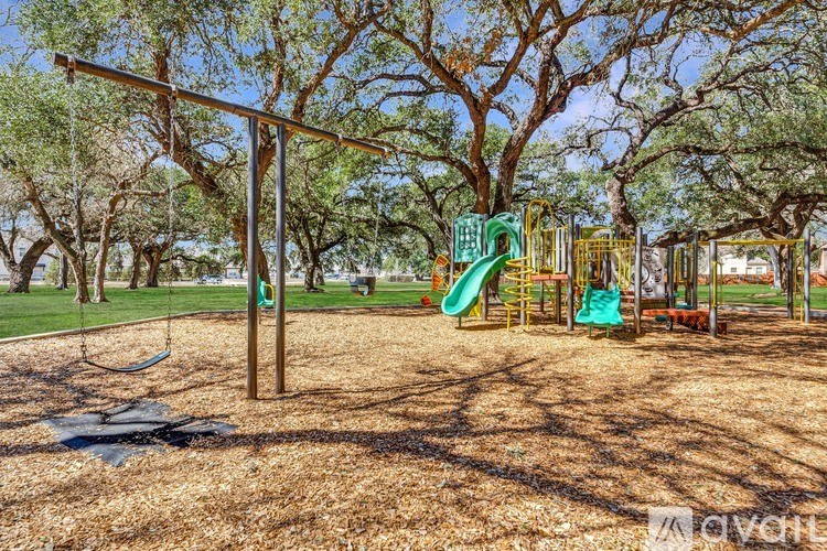 A playground with a green slide and a swing set.