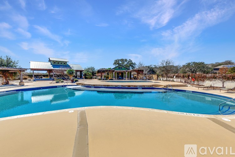 A large swimming pool with a blue sky and clouds in the background.