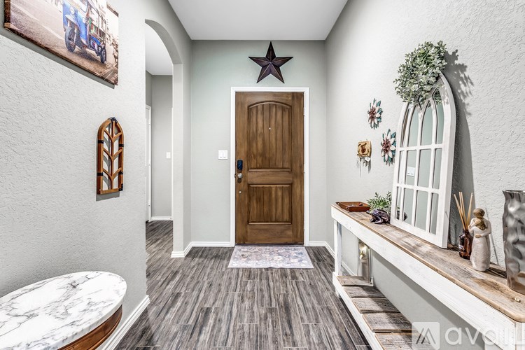 A hallway with a wooden door and a star on the wall.