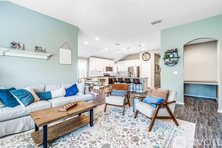 A living room with a white couch and a wooden coffee table.