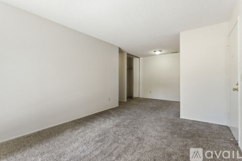 A spacious room with a carpeted floor and white walls.