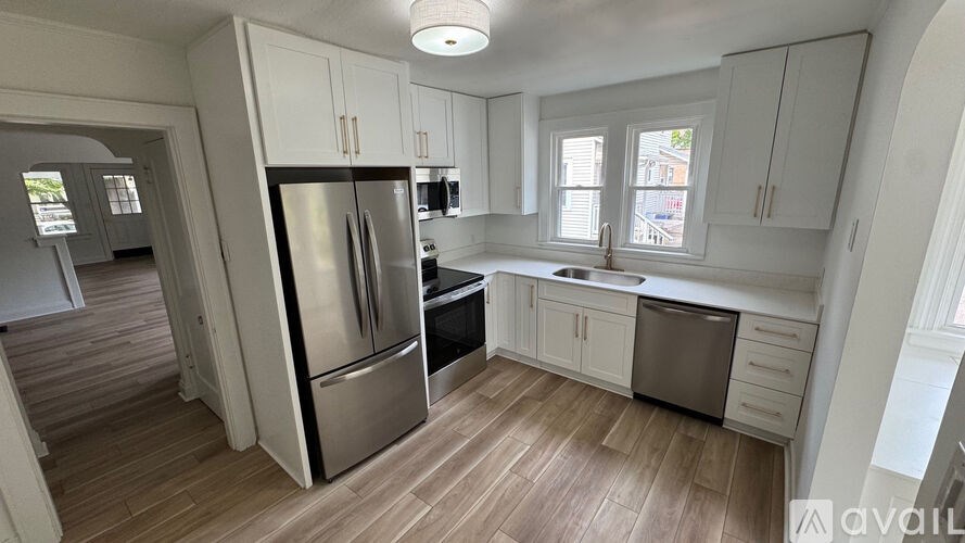 A kitchen with a refrigerator, sink, and cabinets.