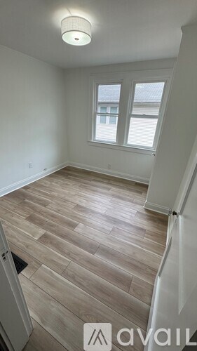 A room with a window and wooden flooring.