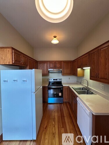 A kitchen with wooden cabinets and a white fridge.