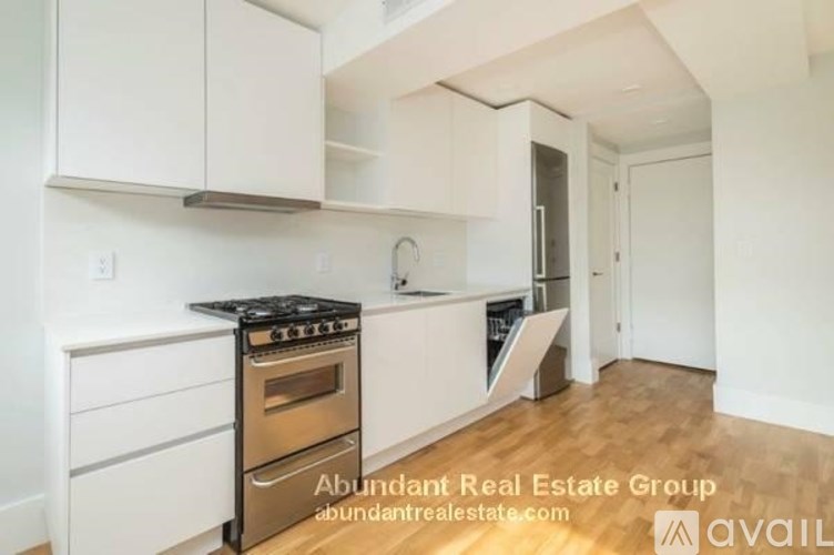 A kitchen with white cabinets and a stove top oven.