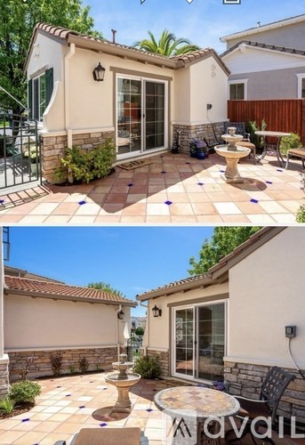 A patio with a table and chairs and a fountain.