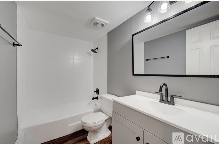 A white toilet sits in a bathroom next to a white sink.