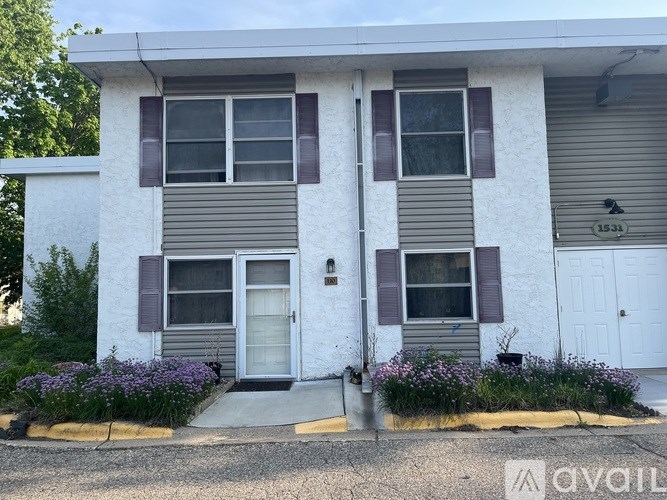 A two-story house with a white and beige exterior and a grey roof.