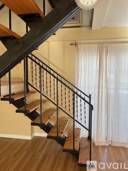 A wooden staircase with a metal railing.