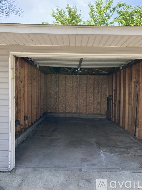 A garage with a white door and wooden walls.