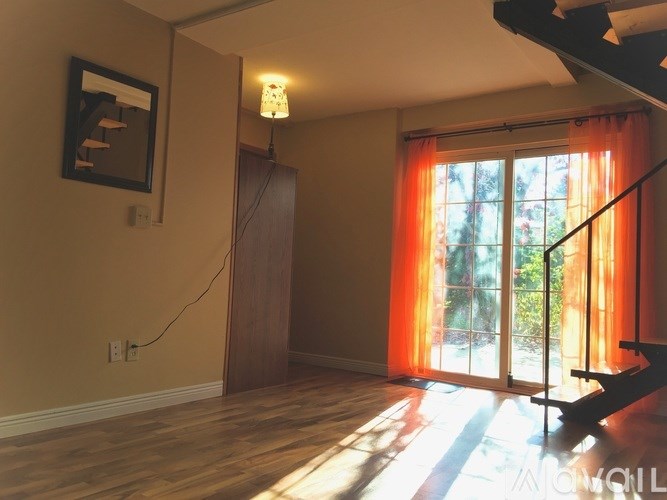 A room with a wooden floor and a painting on the wall.