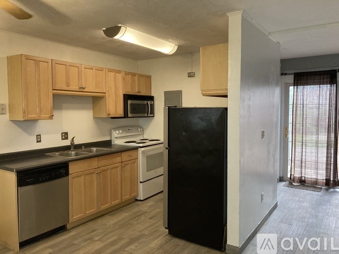 A kitchen with wooden cabinets and black appliances.