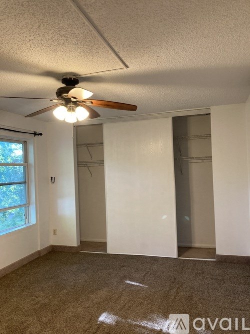 A room with a ceiling fan and a window.