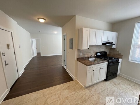 A kitchen with white cabinets and a black stove top oven.