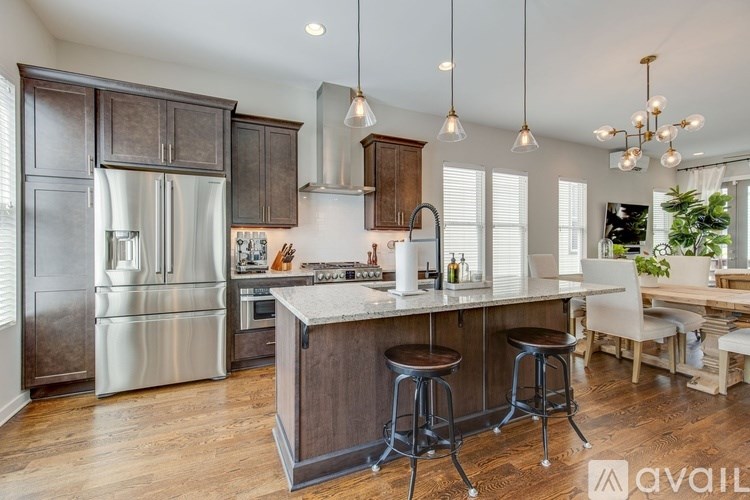 A modern kitchen with a center island and stools.