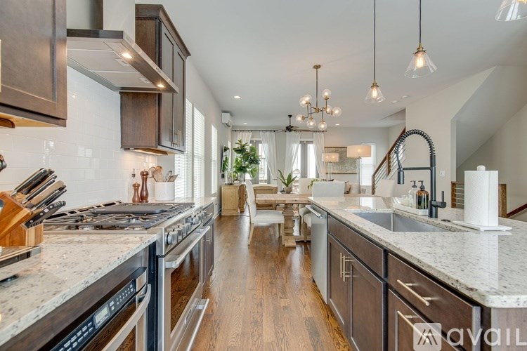 A modern kitchen with dark wood cabinets and a marble countertop.