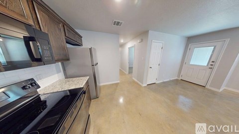 A kitchen with black appliances and wooden cabinets is available for rent.