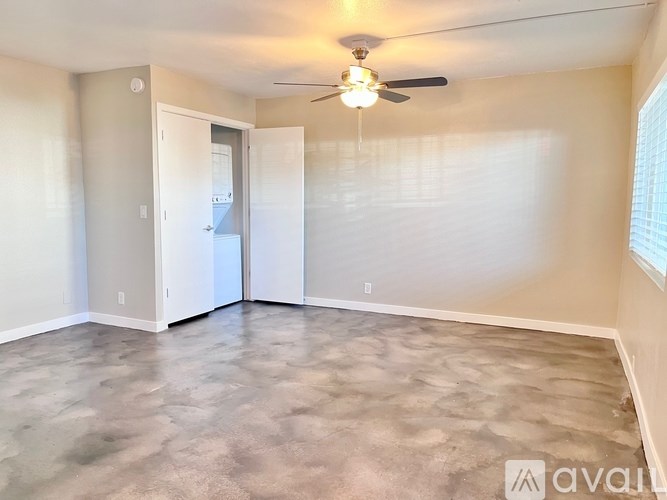 A room with a ceiling fan and a door leading to another room.