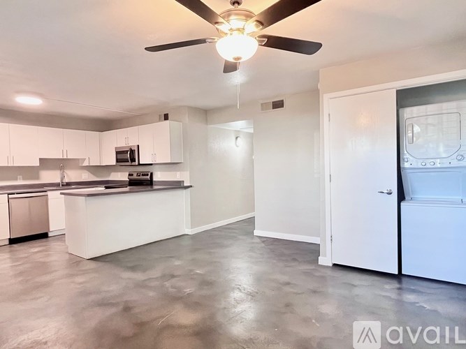 A spacious kitchen with white cabinets and a ceiling fan.