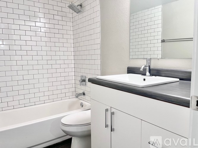 A white bathroom with a toilet, sink, and bathtub.