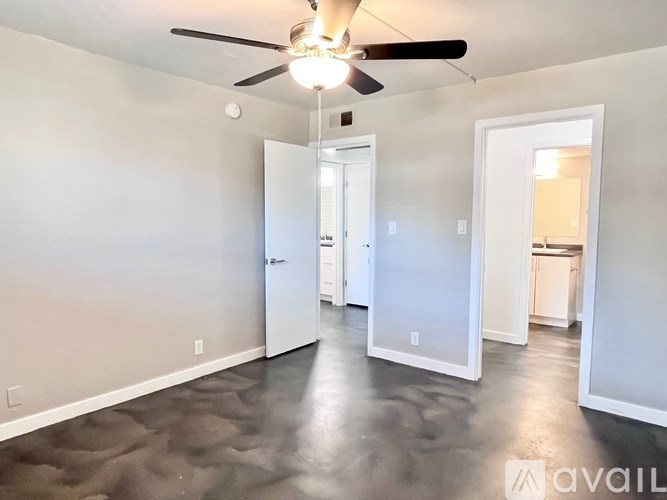 A room with a ceiling fan and a large mirror on the wall.