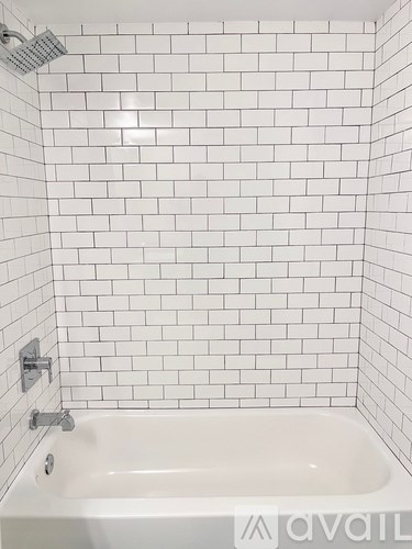 A white bathtub with a shower head above it.