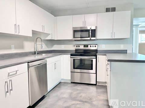 A kitchen with white cabinets and stainless steel appliances.