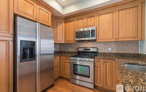 A kitchen with wooden cabinets and stainless steel appliances.