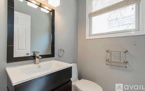 A bathroom with a white sink and a toilet.