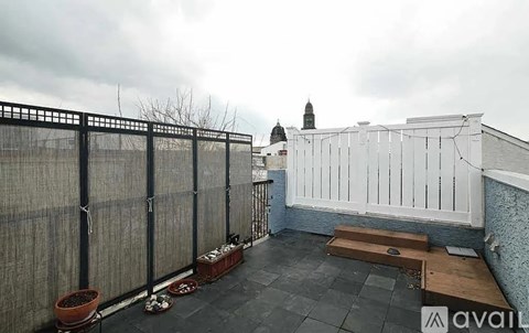 A balcony with a white railing and a view of a building with a dome.