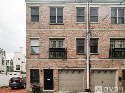 A red brick building with a black car parked in front.