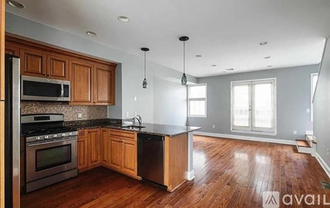 A kitchen with wooden cabinets and a black refrigerator.