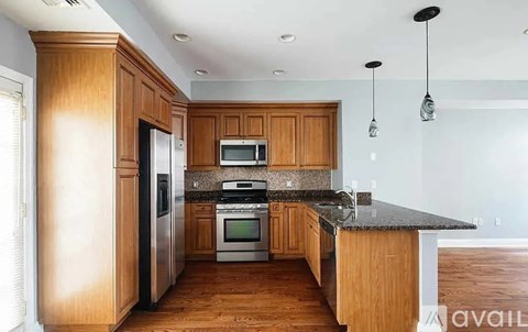 A kitchen with wooden cabinets and a granite countertop.