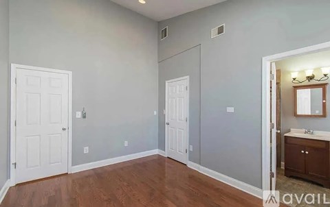 A room with two doors and a cabinet with a mirror above it.