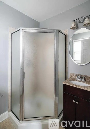 A shower stall with a glass door is in a bathroom.