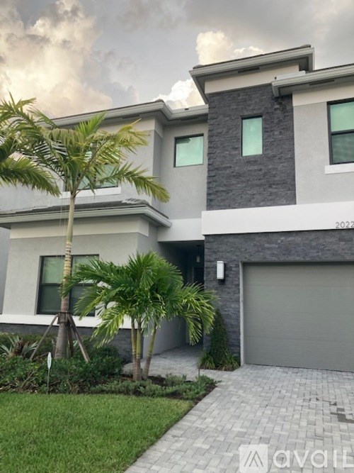 A modern house with a palm tree in front.