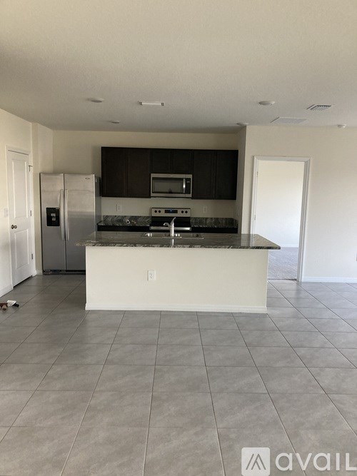 A kitchen with a white island and stainless steel appliances.