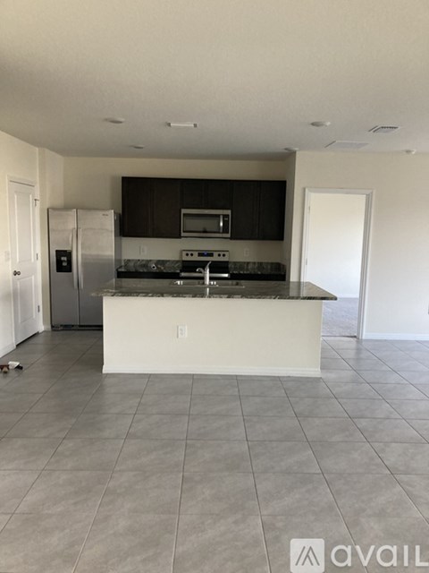 A kitchen with a white island and stainless steel appliances.