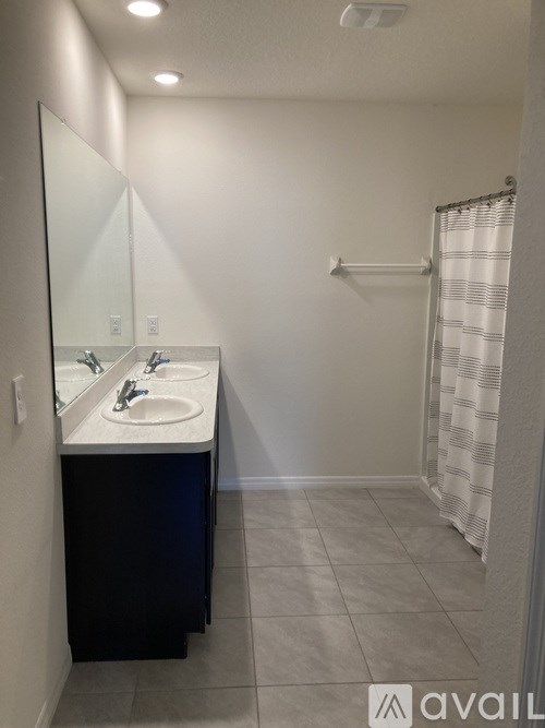 A bathroom with a sink, mirror, and shower.