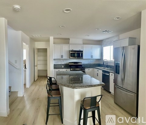 A kitchen with a granite countertop and stainless steel appliances.