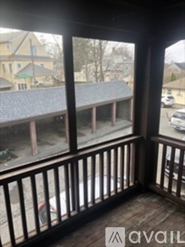 A balcony with a view of a street and houses.