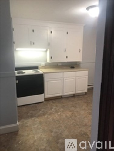 A kitchen with white cabinets and a black countertop.