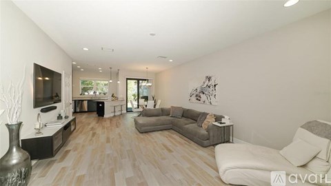 A living room with a grey couch and a wooden floor.