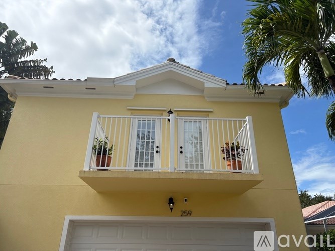 A yellow house with a balcony and a white door.