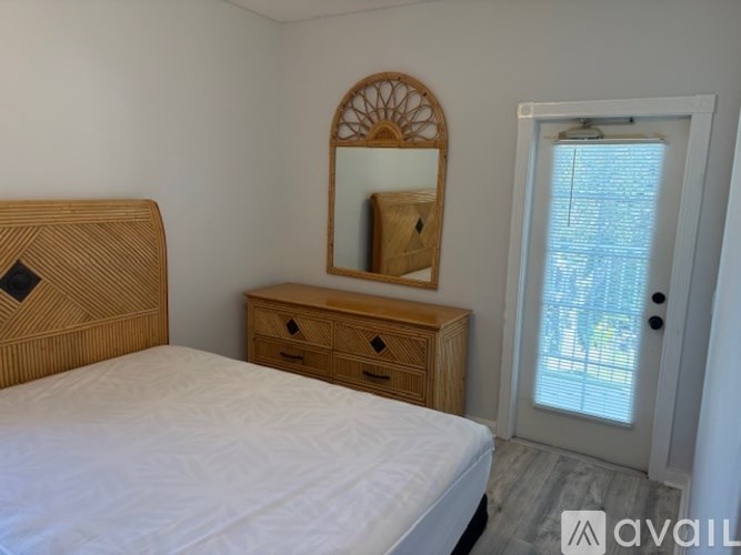 A bedroom with a bed, dresser, and mirror.