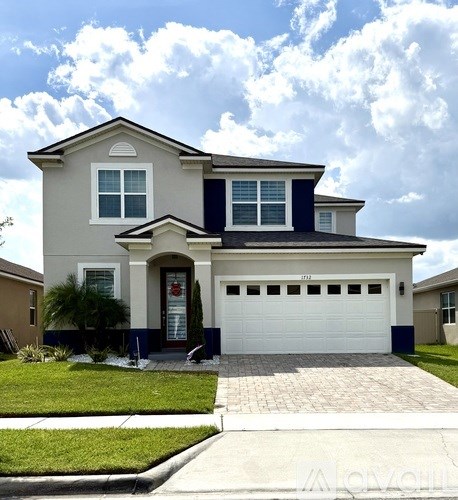 A two-story house with a garage and a driveway.