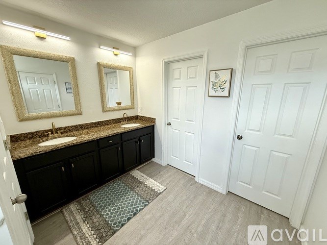 A bathroom with a vanity, two sinks, and a mirror.