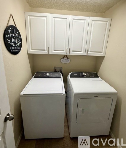 Two white front loading washing machines in a laundry room.
